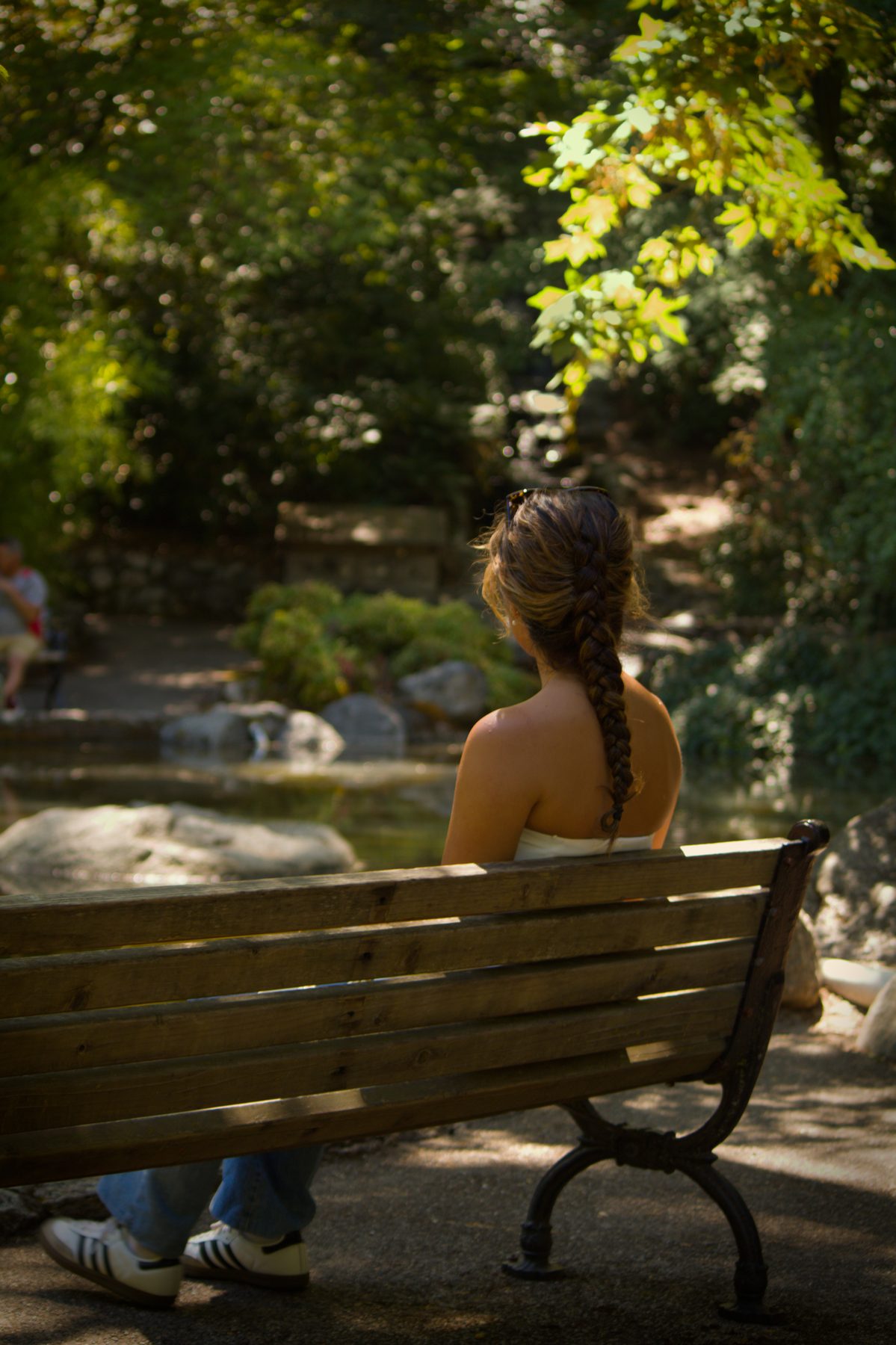 Woman seated on a park bench seen from behind