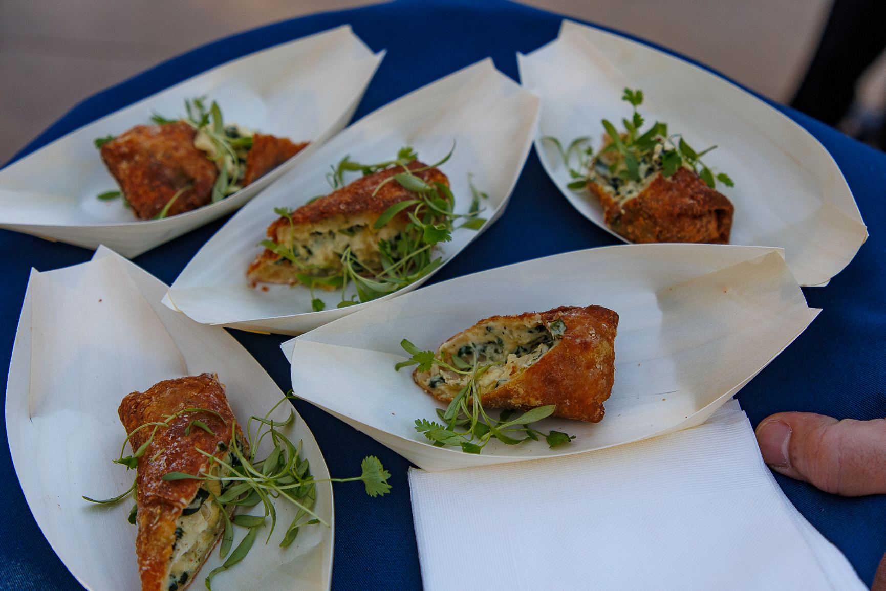 Plated seared fish bites on a blue tablecloth at the BOMA OC event