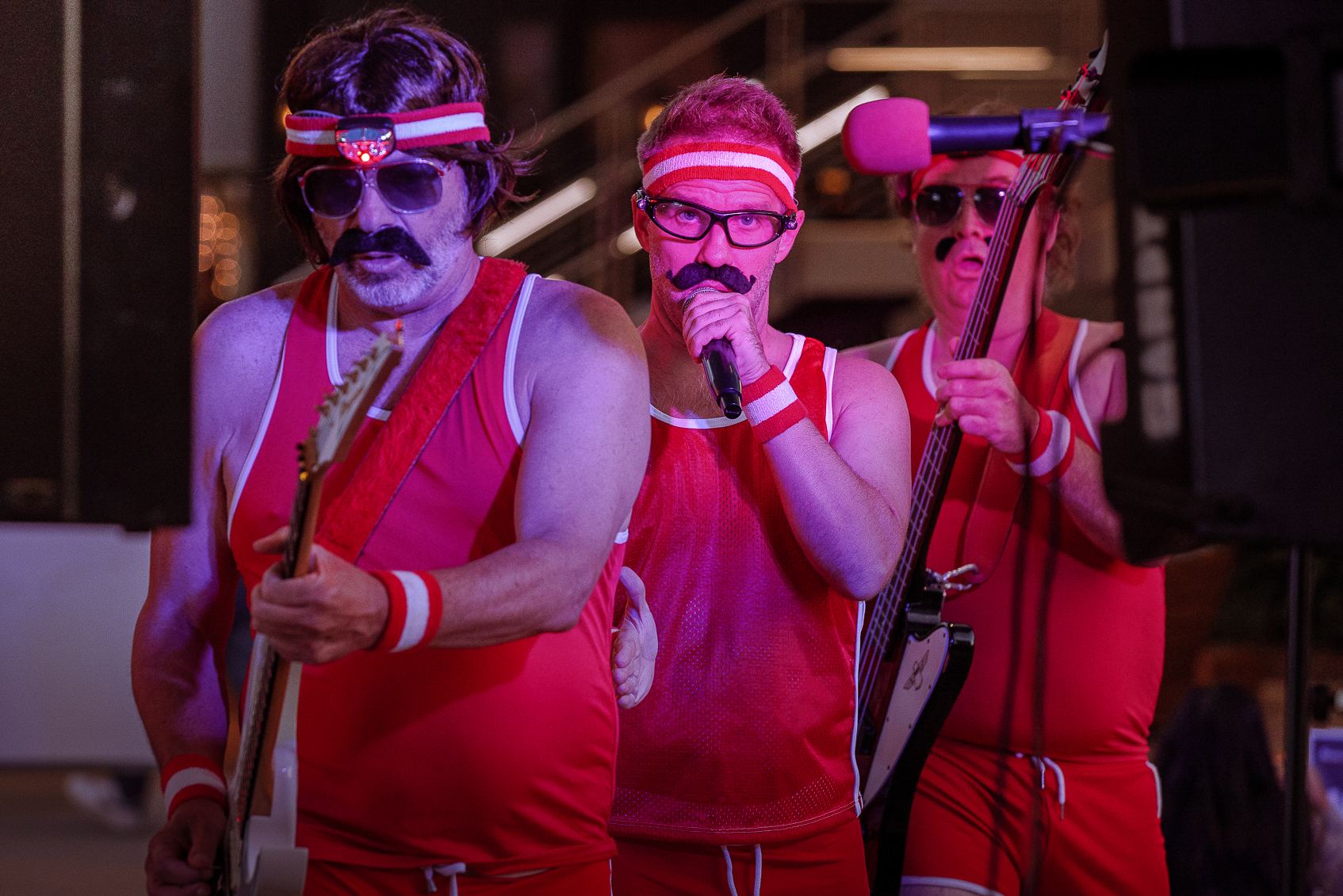 Costumed band performing in red outfits and headbands on stage