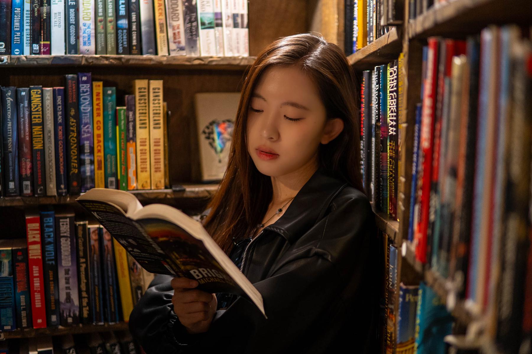 Portrait of a woman reading a book in a library