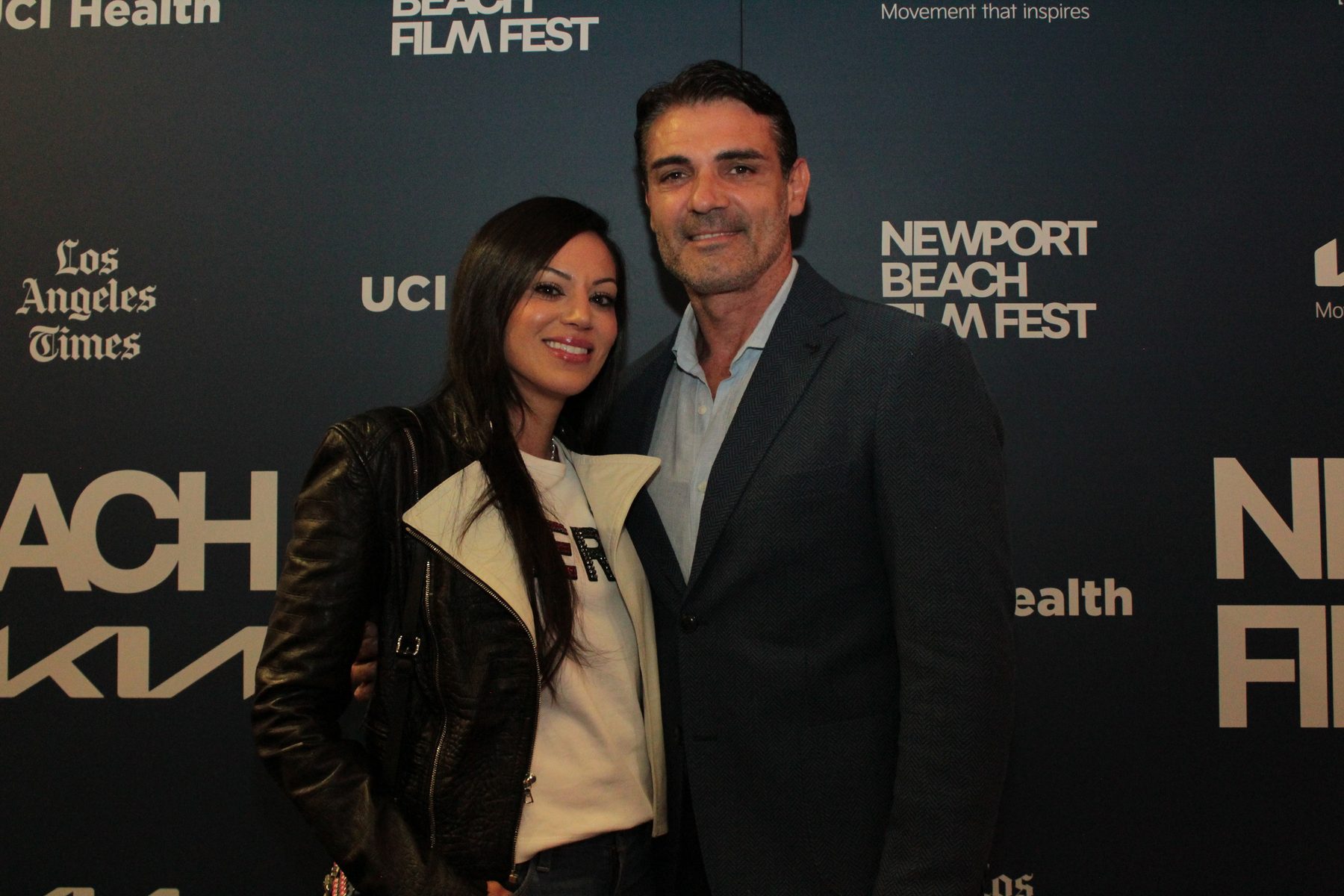 Two guests posing at the Newport Beach Film Festival backdrop