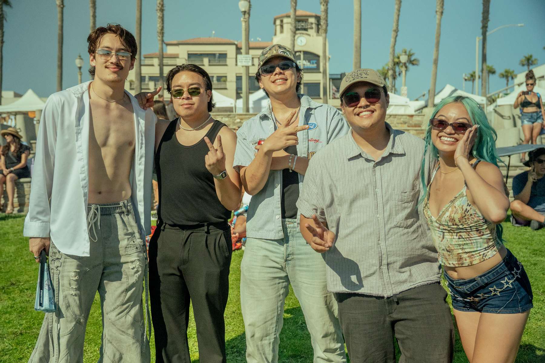Group of friends posing together on the grass at the beach event
