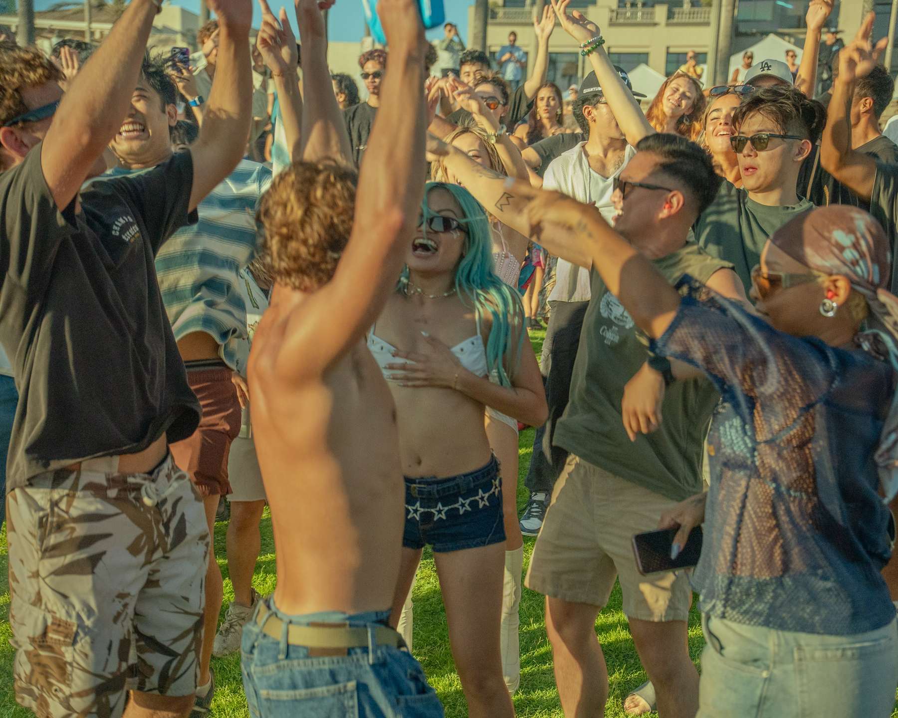 Crowd dancing with their arms in the air at the beach event