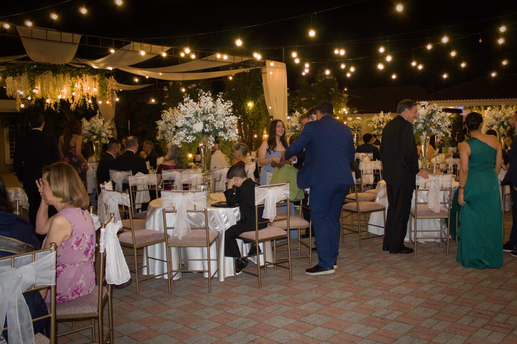 Wedding reception tables under string lights at night