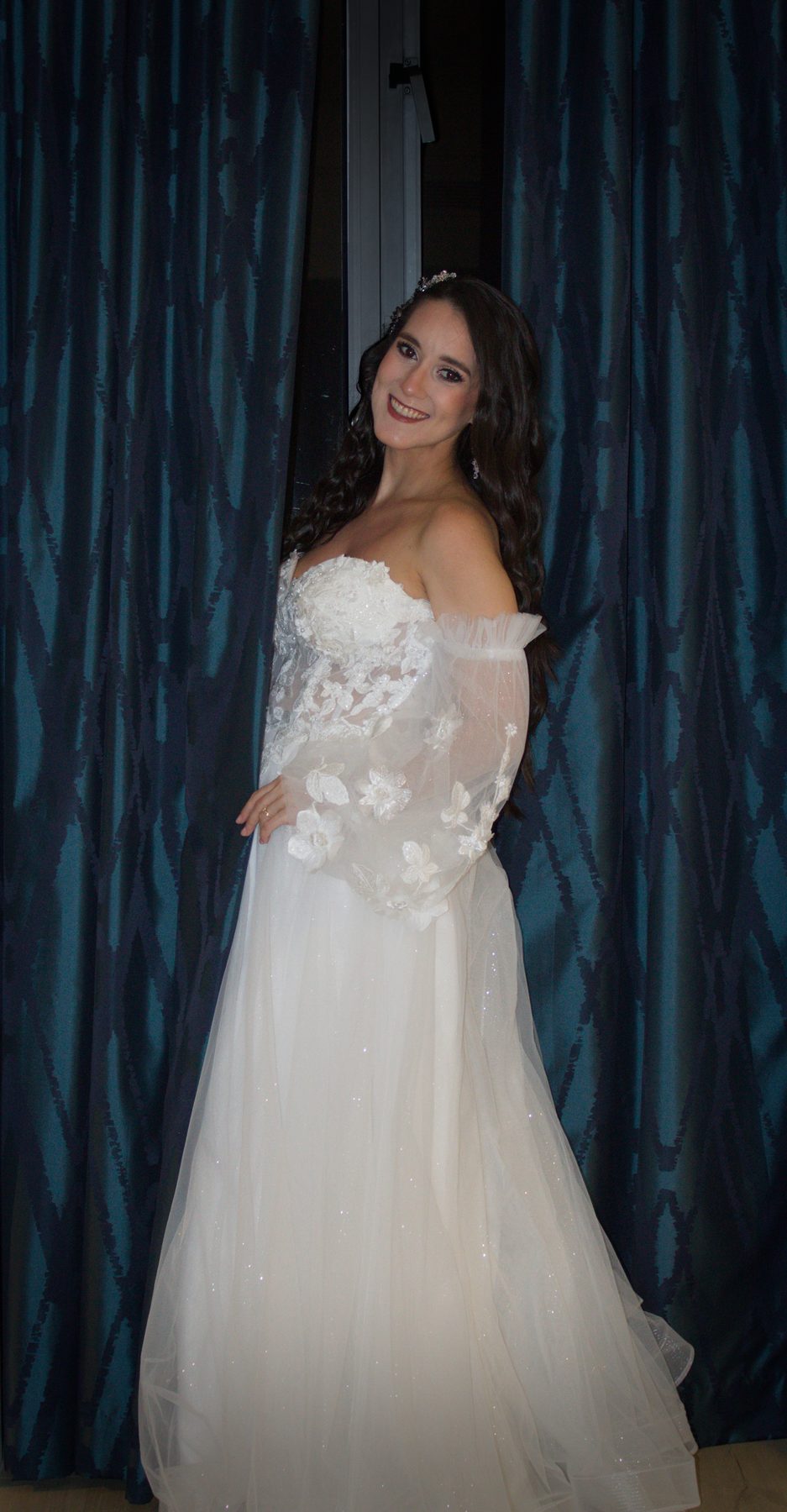 Bride standing in front of dark blue drapes